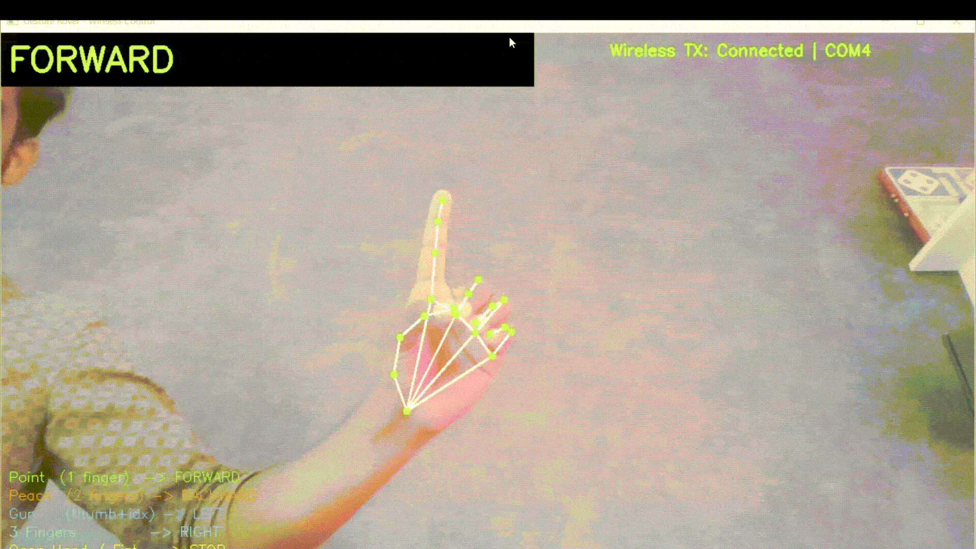 Working demonstration of the real-time hand gesture control robot using OpenCV and Arduino — webcam feed shows MediaPipe hand landmarks while the four-wheel rover responds to Forward, Backward, Left, Right, and Stop gestures